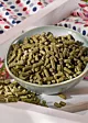 Esparsette Pellets für Pferde in einer gräulichen Schüssel, Tuch mit Punkten im Hintergrund, Pferdefutter